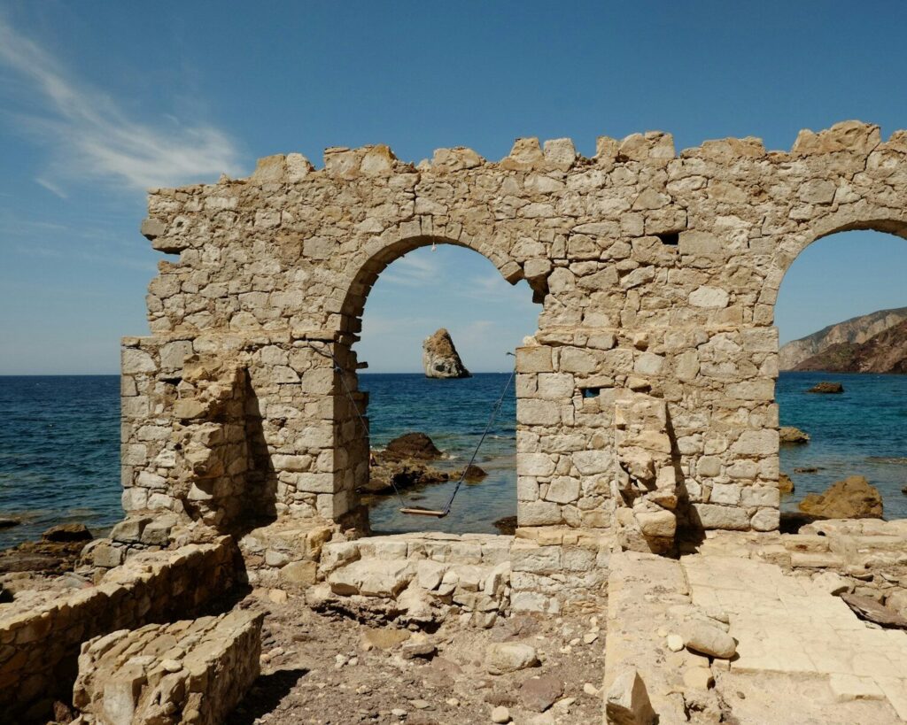 An old stone building sitting on top of a rocky beach