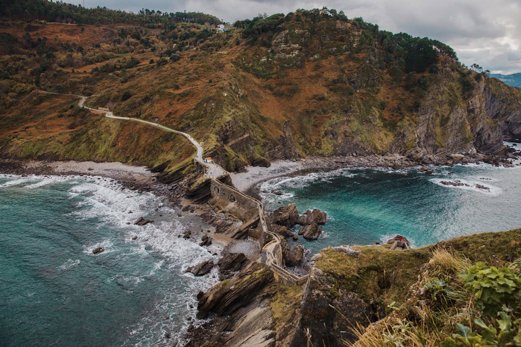 A breathtaking view of Gaztelugatxe's rugged coastline, showcasing its scenic cliffs and turquoise waters.