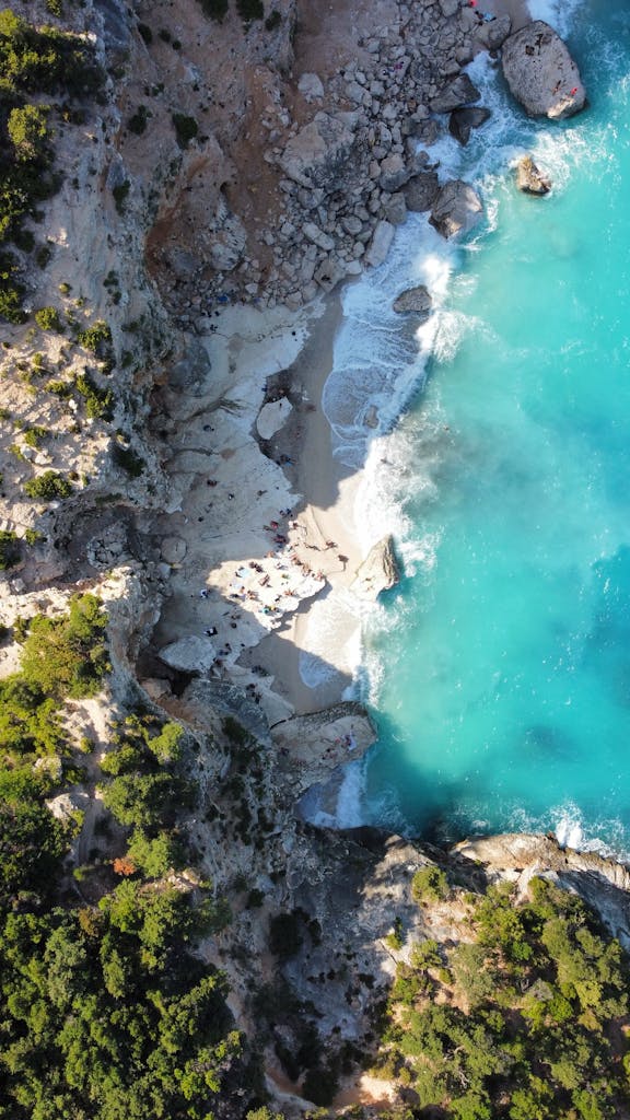 Breathtaking aerial photo of Cala Goloritzé beach in Sardinia with turquoise waters and rugged cliffs.