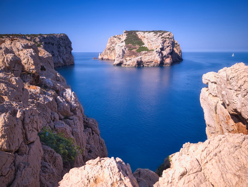 Breathtaking coastal cliffs and azure waters near Alghero, Sardinia. Perfect summer travel destination.