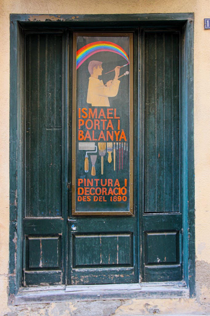 Old wooden door featuring a vintage artistic advertisement sign with colorful design elements.
