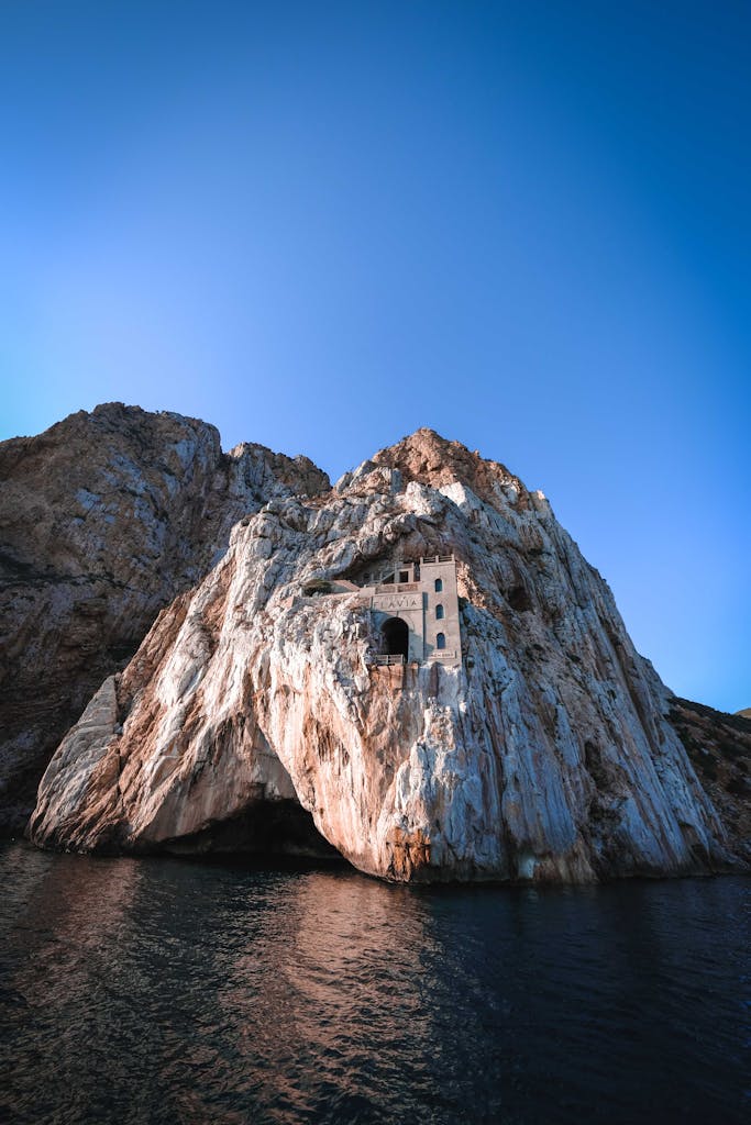 Stunning view of Porto Flavia's rock formations against the blue sea in Sardinia.