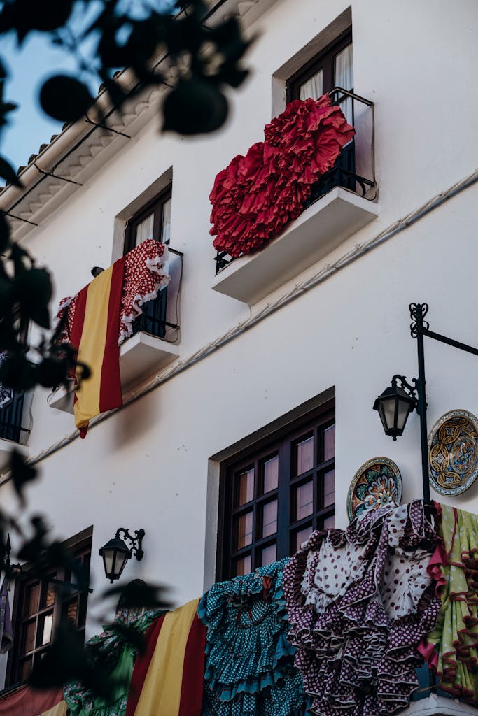Vibrant decorative fabrics and Spanish flags on balconies in Marbella, Spain.