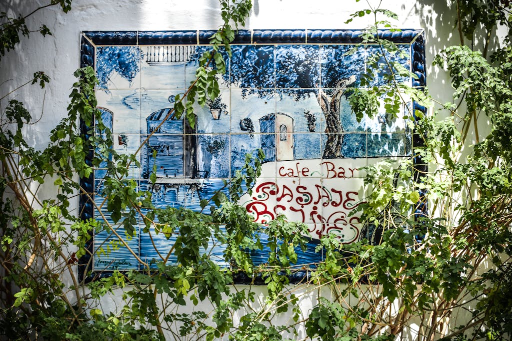 Vibrant outdoor wall art depicting a Spanish café surrounded by lush greenery in Estepona.